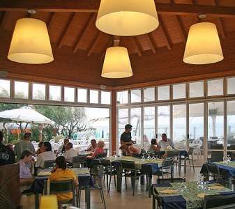 Un ristorante con tavoli apparecchiati e persone sedute.