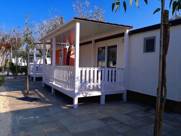 Casa mobile con veranda bianca e pavimento piastrellato.
