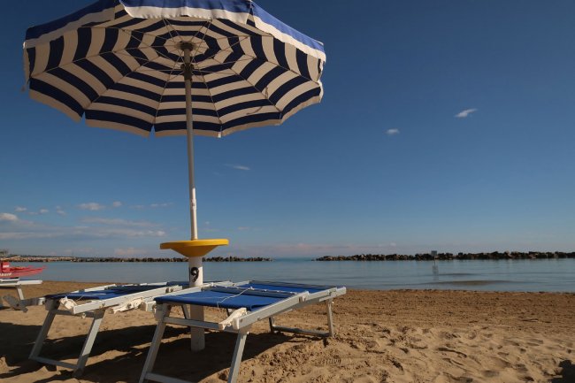 Ombrellone a righe su una spiaggia.