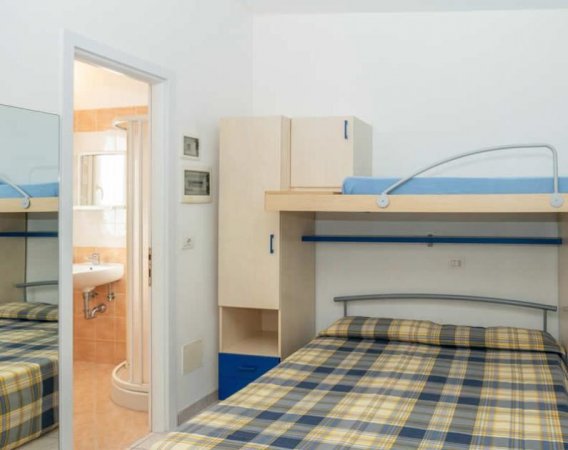 Camera con letto a castello, armadio e bagno annesso.