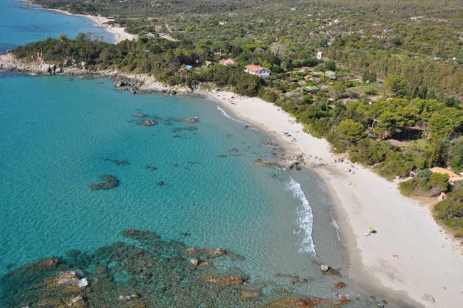 Vista aerea di una spiaggia con mare turchese.