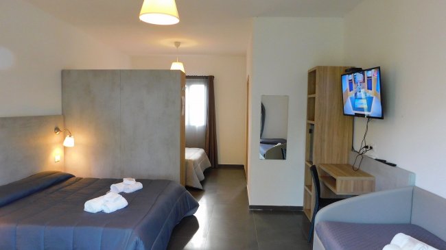 Camera d'albergo con letto matrimoniale e TV.