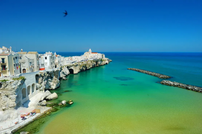 Baia con città costiera e acqua verde smeraldo.