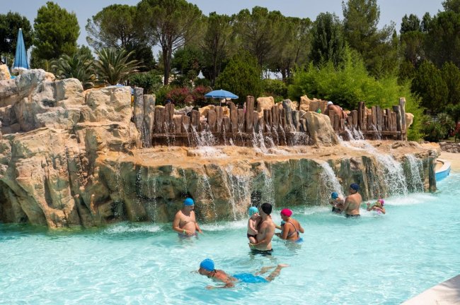 Piscina con cascate artificiali e nuotatori.