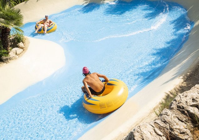 Persone su gonfiabili su uno scivolo d'acqua.