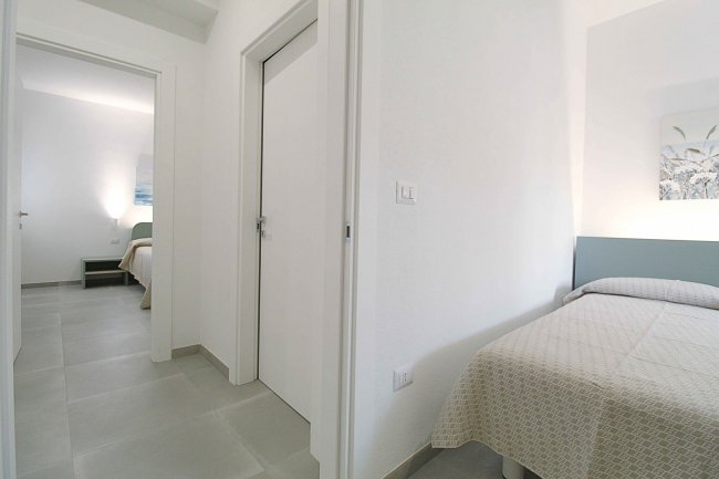 Corridoio con due stanze e porte bianche.