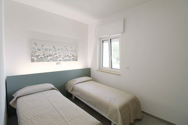 Due letti singoli in una stanza luminosa.