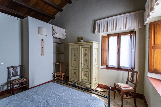 Camera con armadio decorato e due sedie.