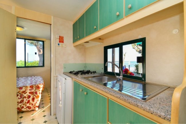 Cucina con finestra, lavello e fornelli.