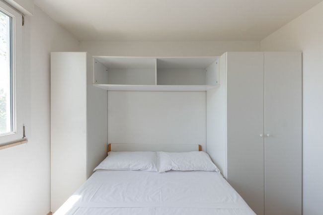 Letto con armadio a muro.