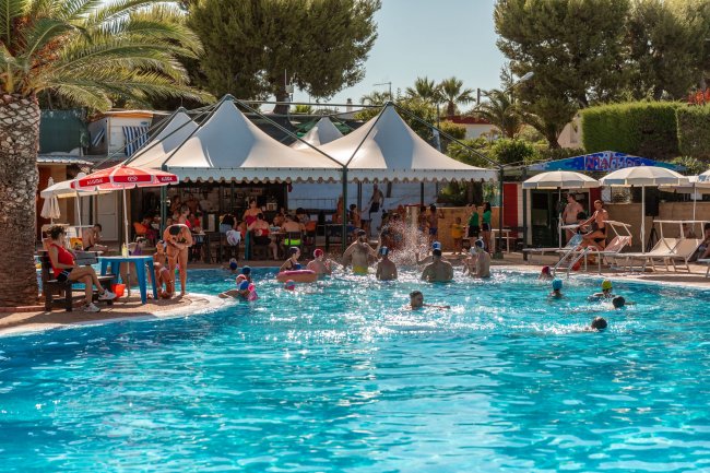 Piscina con bagnanti e ombrelloni.