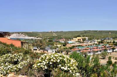 Vista panoramica di un borgo con case e vegetazione collinare.