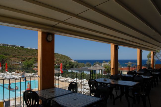 Area pranzo con vista piscina e mare.