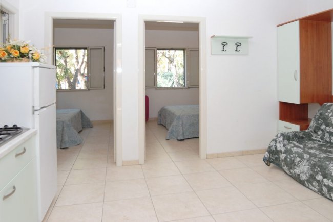 Interno luminoso con due letti e cucina.