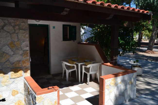 Veranda con tavolo e sedie bianche all'aperto.