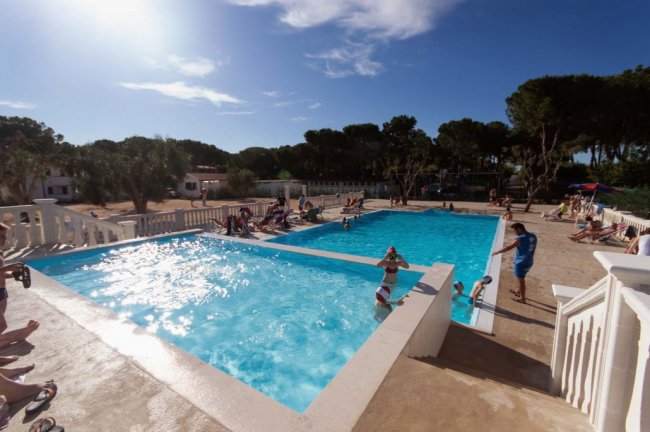 Ampia piscina con persone a bordo vasca.