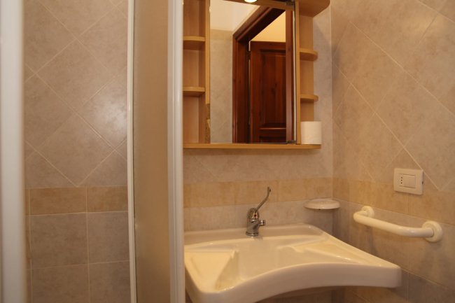 Bagno con piccolo lavabo e specchio.