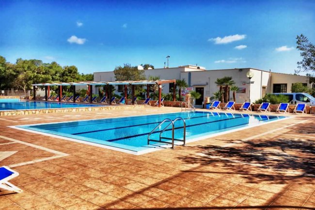 Piscina con sdraio e ombrelloni.