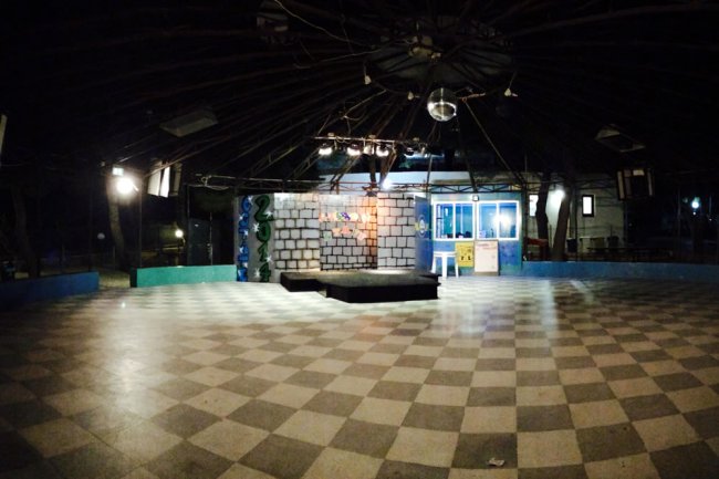 Sala con pavimento a scacchi e piccolo palco.