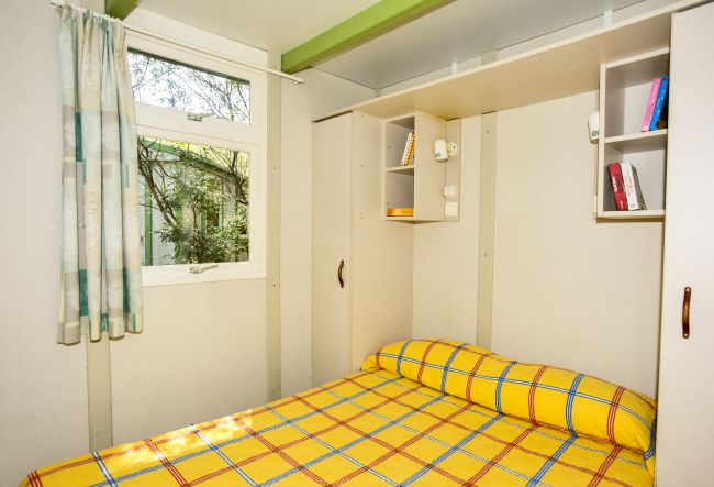 Camera con letto matrimoniale e finestre.