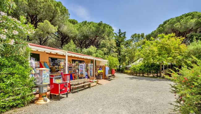 Chiosco in un giardino con alberi e bancarelle.