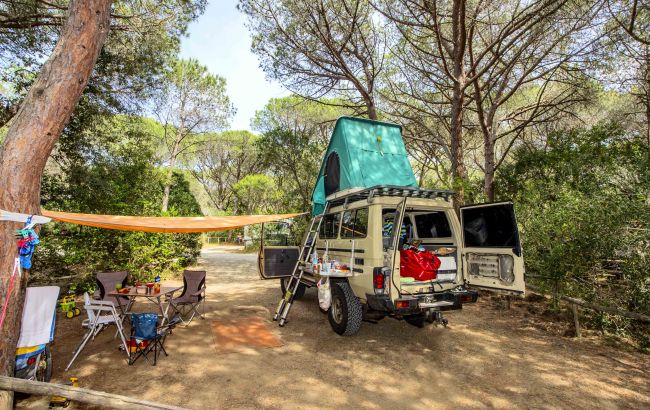 Veicolo fuoristrada con tenda sul tetto in campeggio.