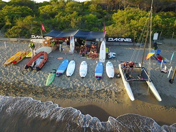 Tavole da surf e barca a vela sulla sabbia.