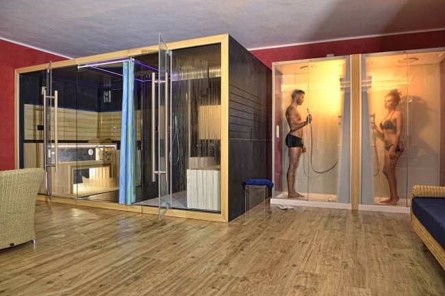 Spa con docce e sauna, due persone si rilassano.