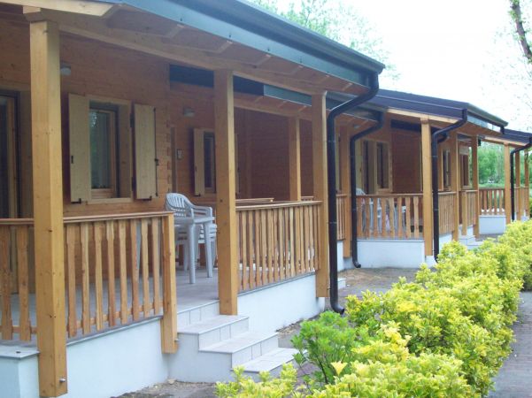 Veranda di bungalow in legno con sedie bianche.