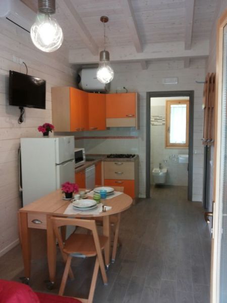 Cucina moderna con mobili arancioni e tavolo apparecchiato.