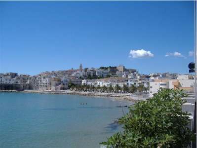 Vista su un borgo costiero con edifici bianchi e mare azzurro.