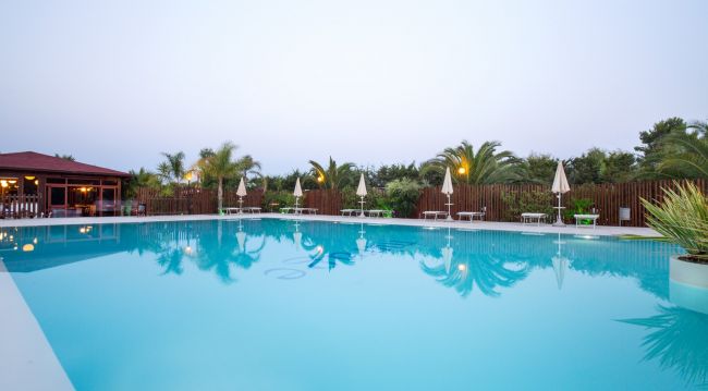Piscina grande con ombrelloni e lettini.