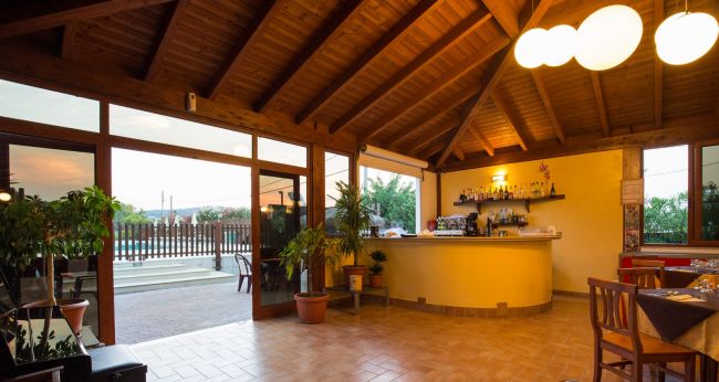 Interno di un bar con tetto di legno e piante in vaso.