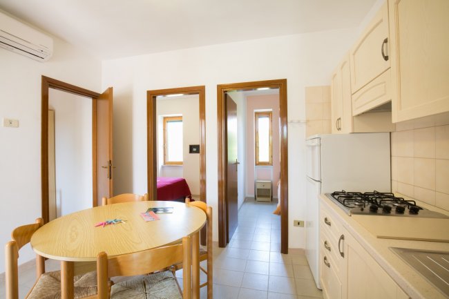 Cucina con tavolo rotondo e porte rosse.