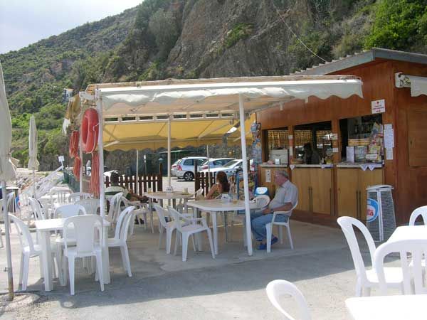 Un piccolo caffè all'aperto con tavoli e sedie sotto un tendone.