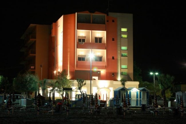 Hotel illuminato di notte vicino alla spiaggia.