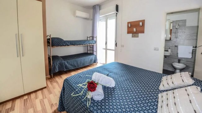 Camera con letto matrimoniale e letti a castello.