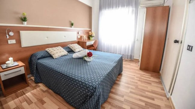 Camera con letto matrimoniale e luce naturale.