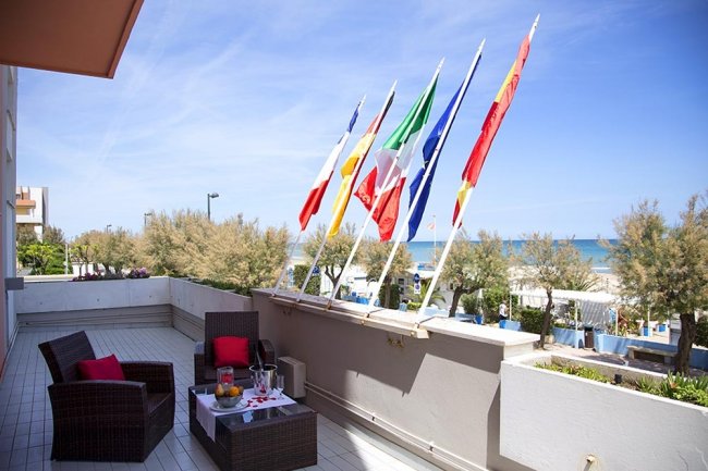 Terrazza con sedie e bandiere, vista mare.
