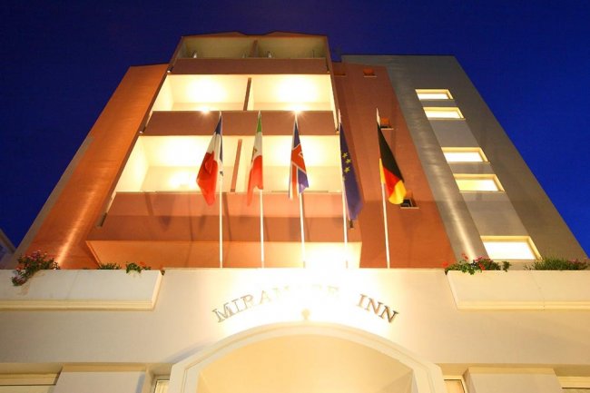 Edificio illuminato di notte con bandiere esposte.
