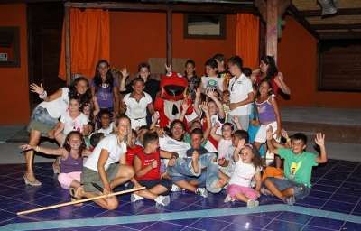 Gruppo di bambini e adulti in festa con un costume rosso.
