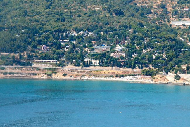 Vista su una costa alberata e mare azzurro.