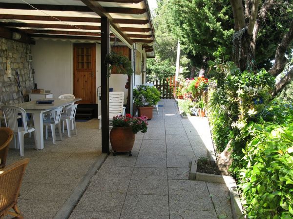 Veranda con tavolo all'aperto e piante intorno.