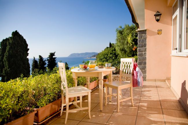Terrazza con tavolo, sedie e vista mare.