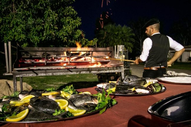 Cuoco griglia pesce all'aperto.