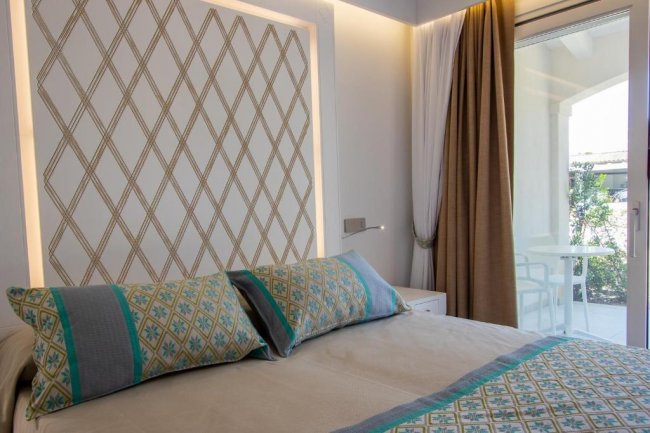 Camera da letto con letto matrimoniale e cuscini decorati.