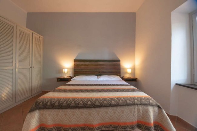Camera da letto con letto matrimoniale e armadio bianco.