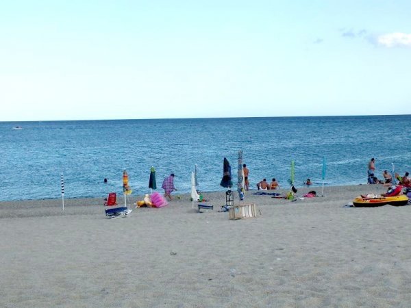Spiaggia affollata con persone in riva al mare.