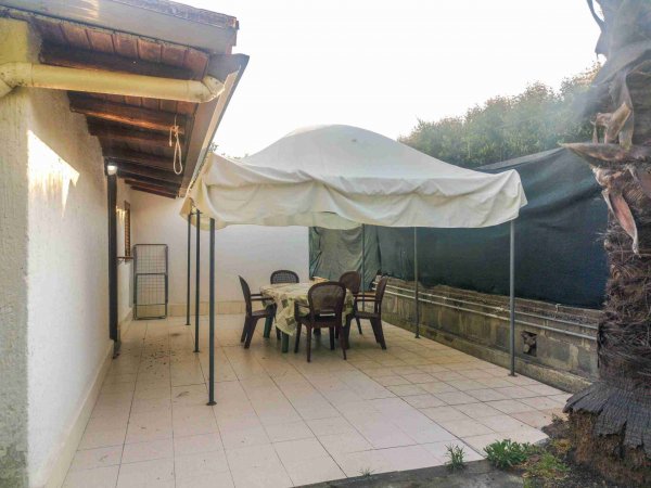 Terrazza con tavolo e sedie sotto un gazebo.