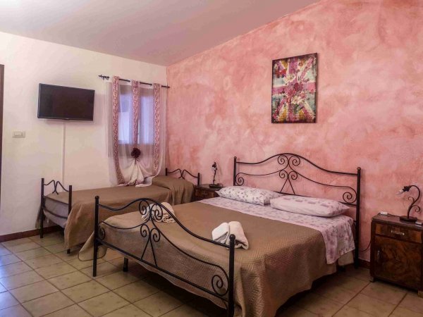 Camera doppia con letti singoli, pareti rosa.